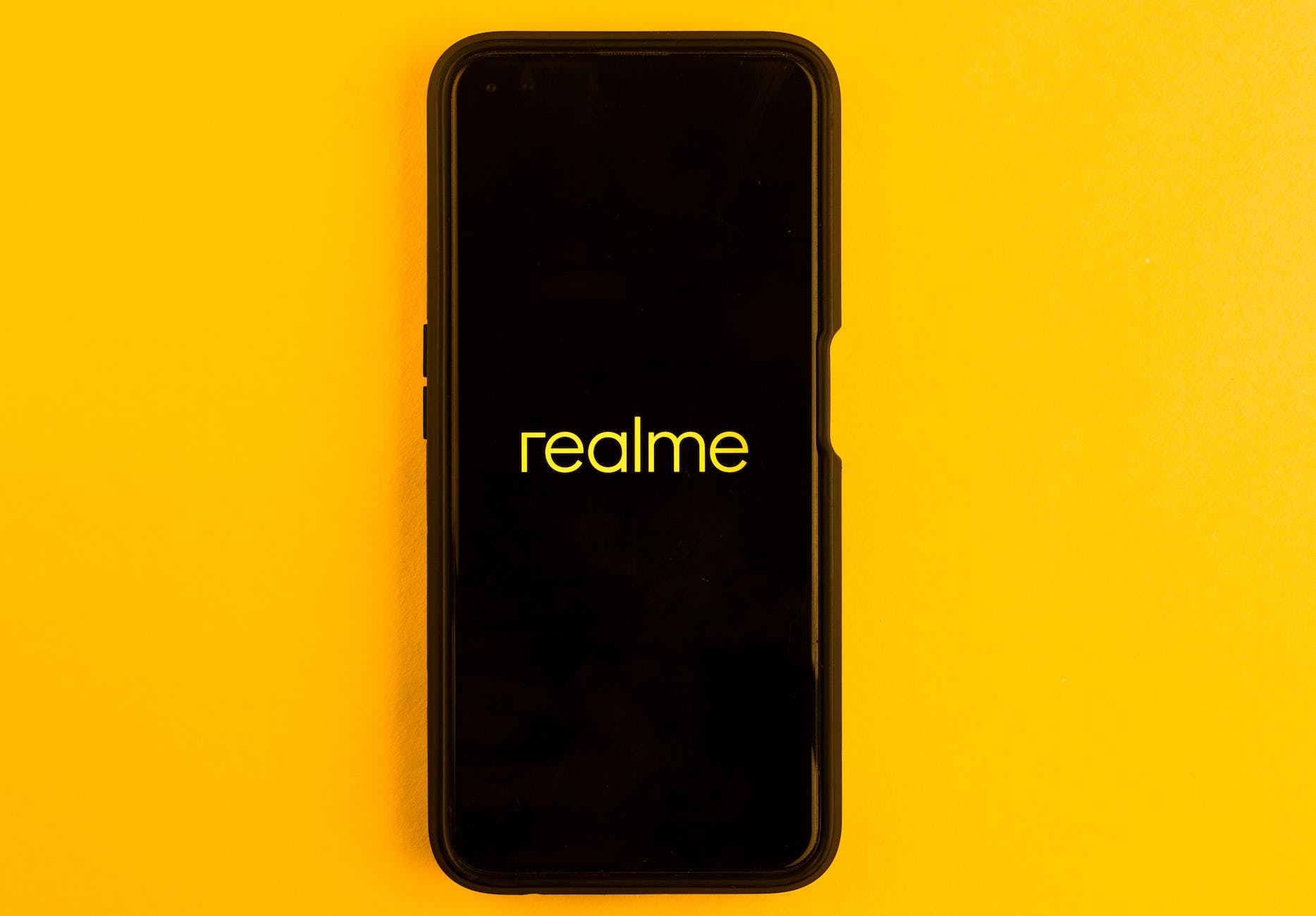in this photo illustration the realme logo seen displayed on a smartphone and on the background